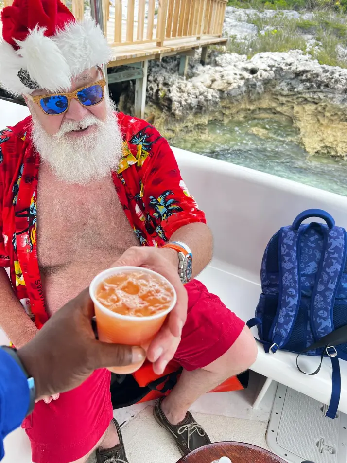 Guest in a Santa hat celebrating aboard a Seas N' Cays catamaran in the Bahamas