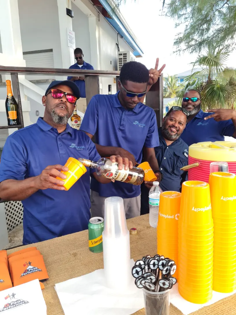Seas N' Cays crew member in a branded blue shirt serving guests during a wedding celebration