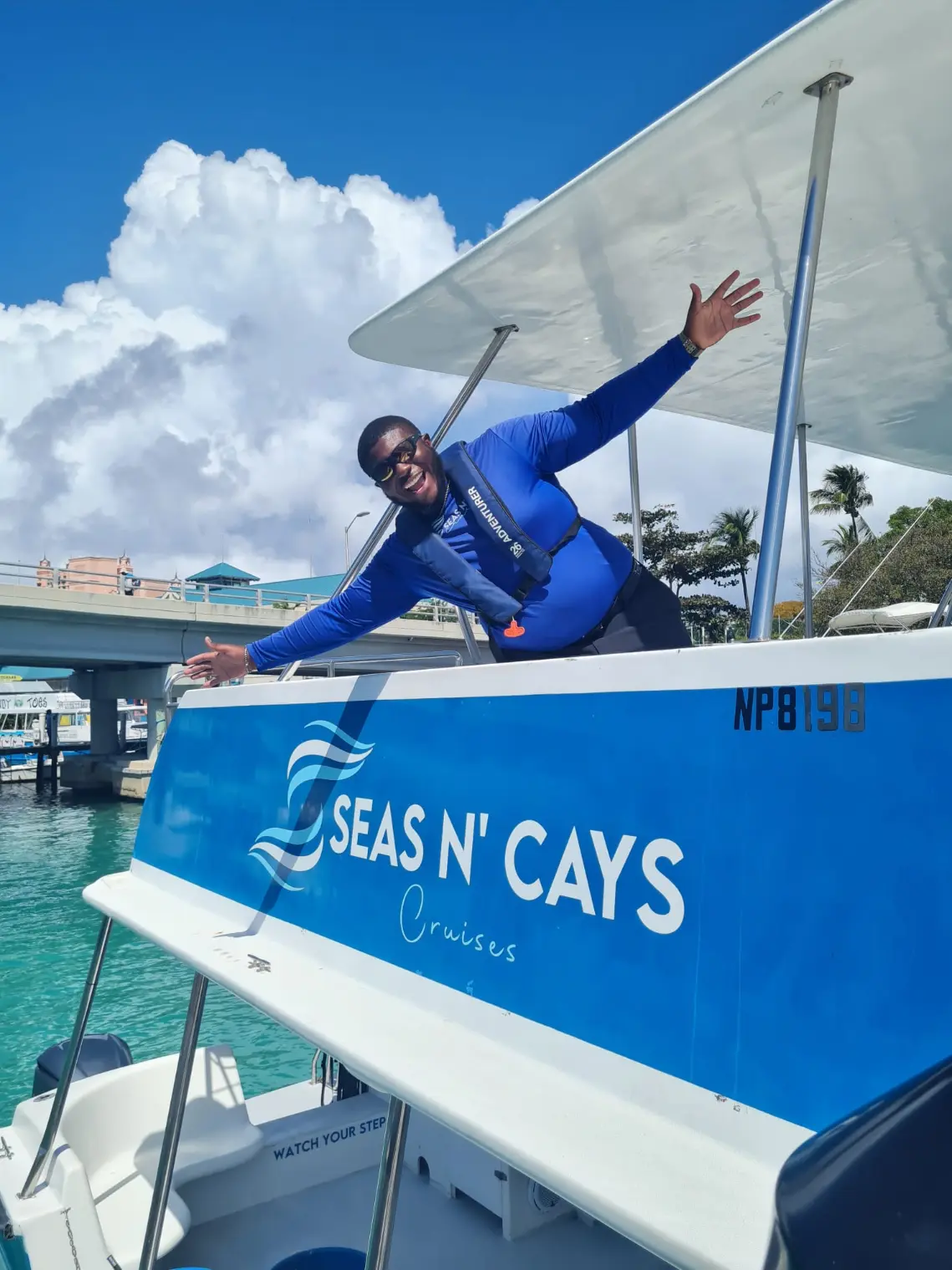 Seas N' Cays crew member on deck with the turquoise catamaran hull behind him
