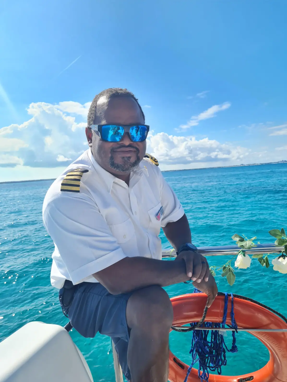 Seas N' Cays captain at the helm of the catamaran on the way to Rose Island