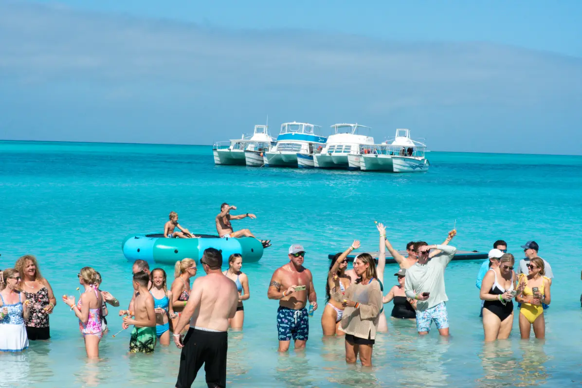 Wedding guests swimming in the turquoise shallows at Rose Island