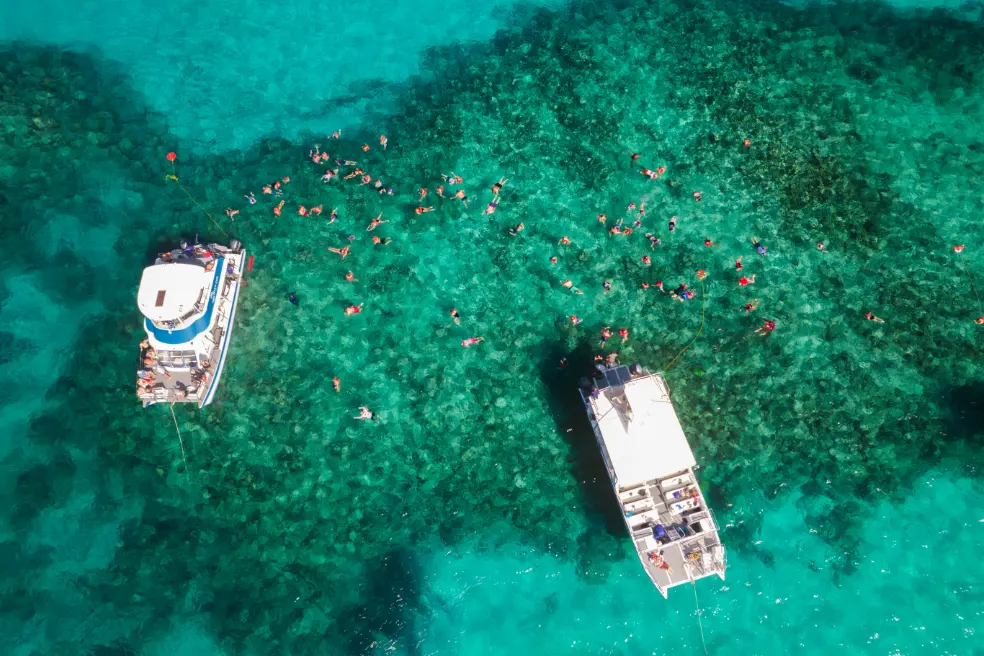 Guests relaxing on the shaded deck of a Seas N' Cays catamaran in the Bahamas