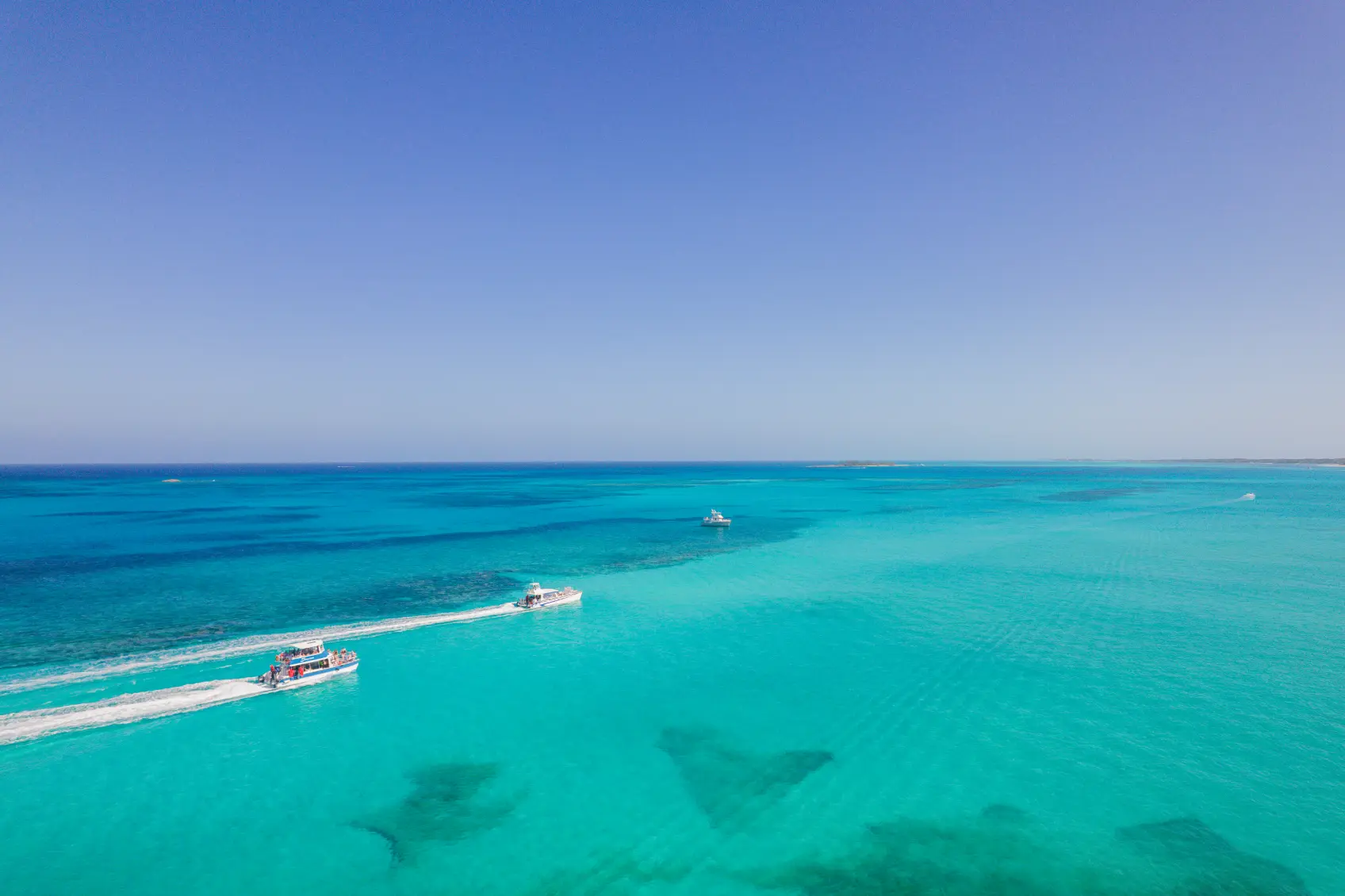 Clear turquoise water over a shallow Bahamian reef seen from above